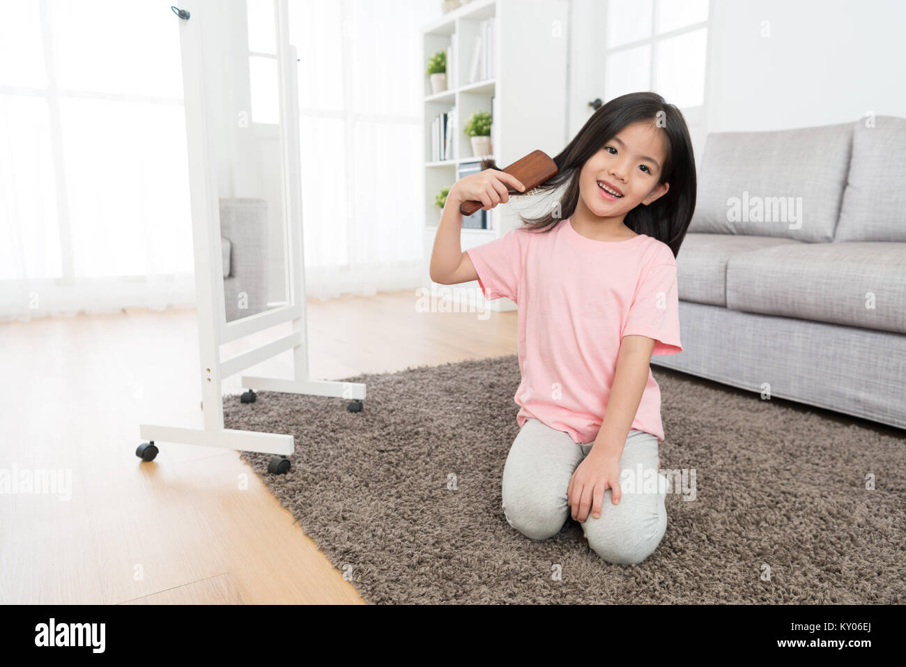 happy beauty girl children combing hair by herself. Stock Photo