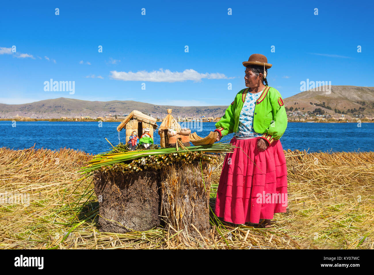 PUNO, PERU - MAY 14, 2015: Unidentified woman in traditional dress showing handicrafts in Uros Island. Stock Photo
