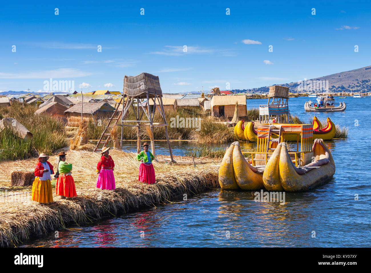 PUNO, PERU - MAY 14, 2015: Unidentified women in traditional dresses welcome tourists in Uros Island. Stock Photo