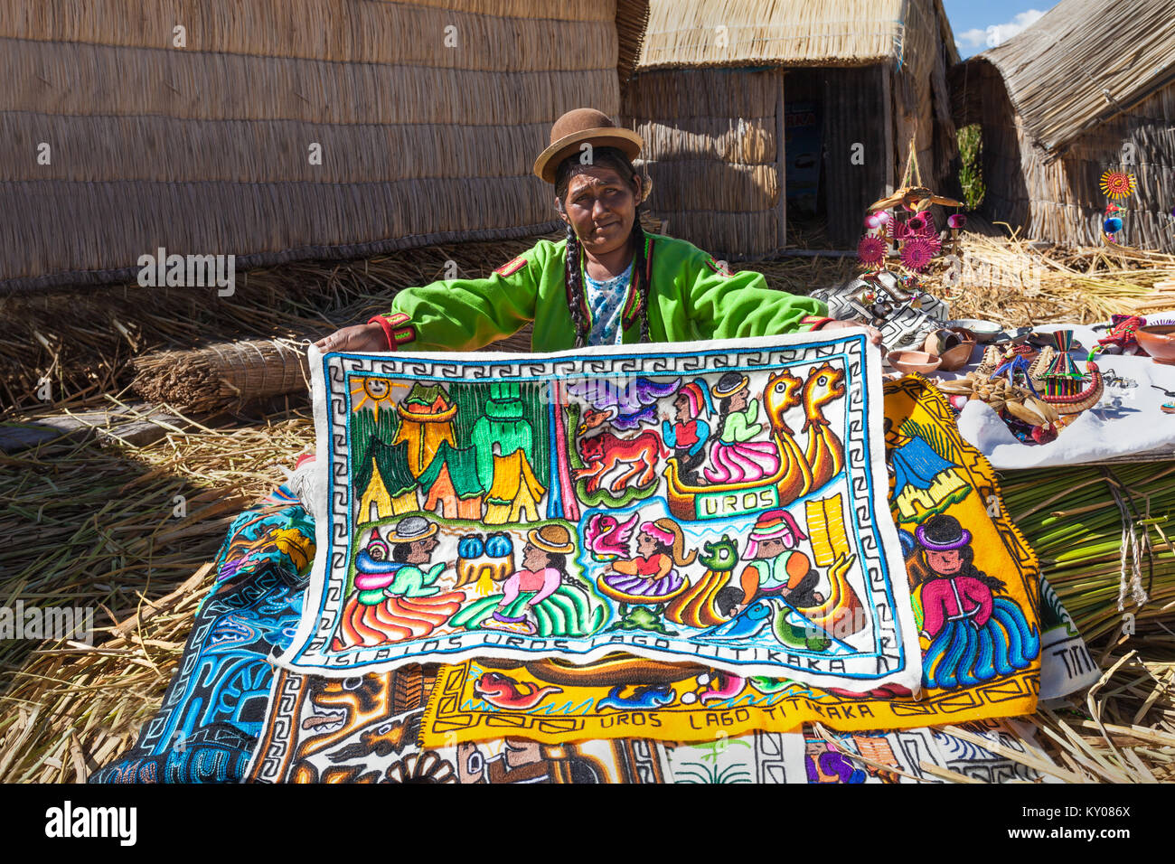 PUNO, PERU - MAY 14, 2015: Unidentified woman in traditional dress showing handicrafts in Uros Island. Stock Photo