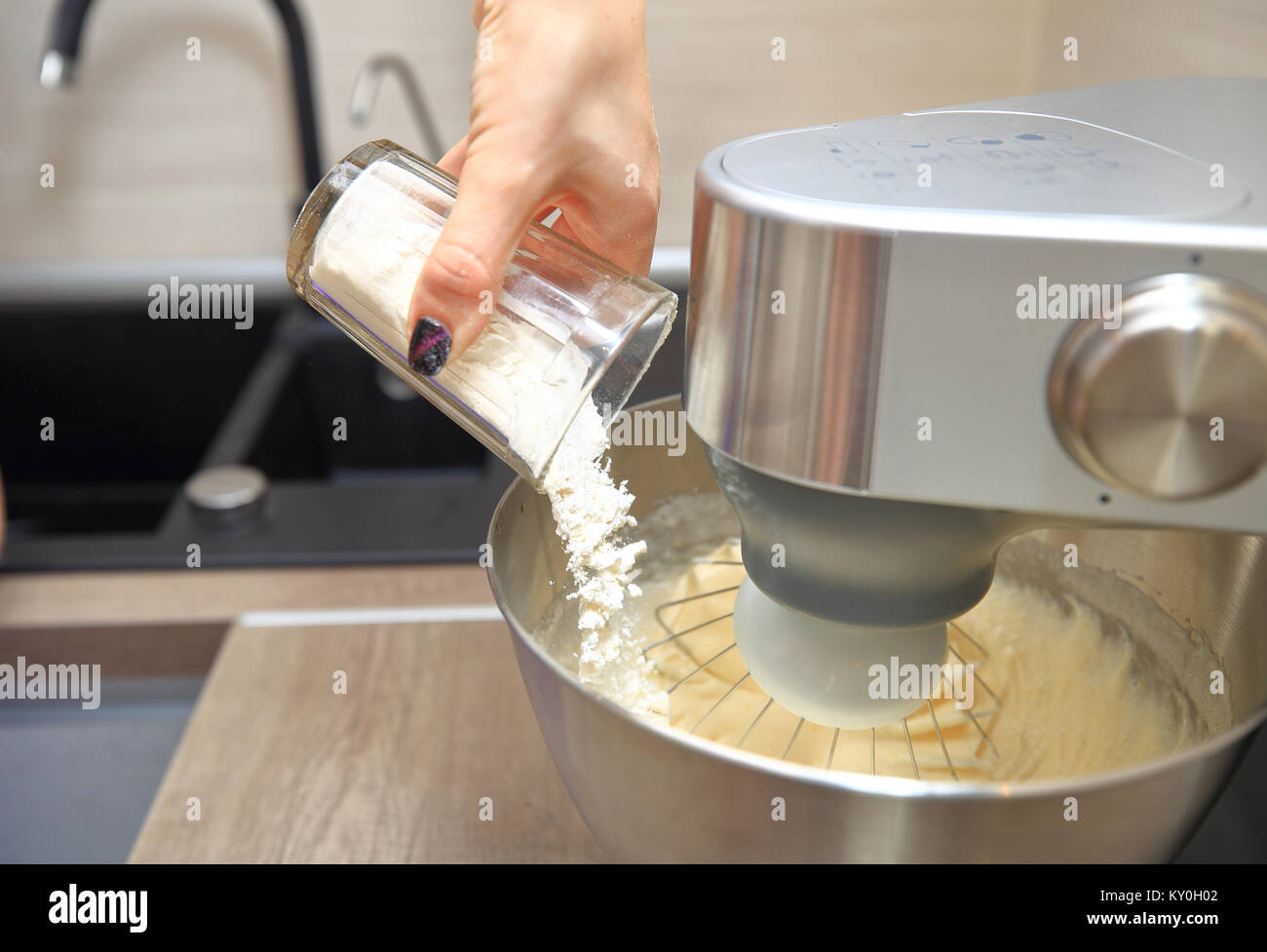 Flour pouring into bowl of food processor close-up. Mixing dough with professional food processor. Stock Photo