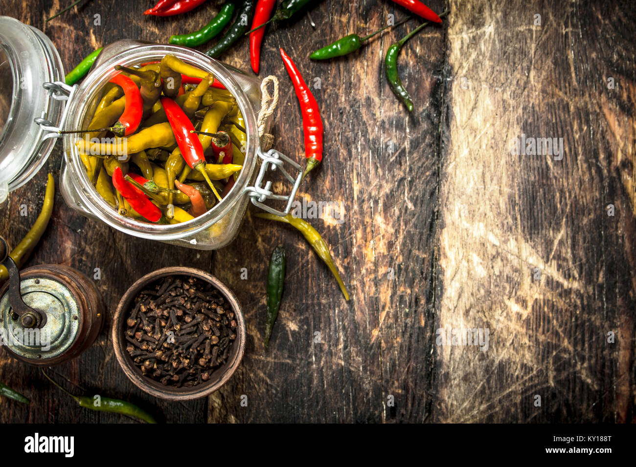 Pickled chili peppers with spices. On a wooden background Stock Photo ...