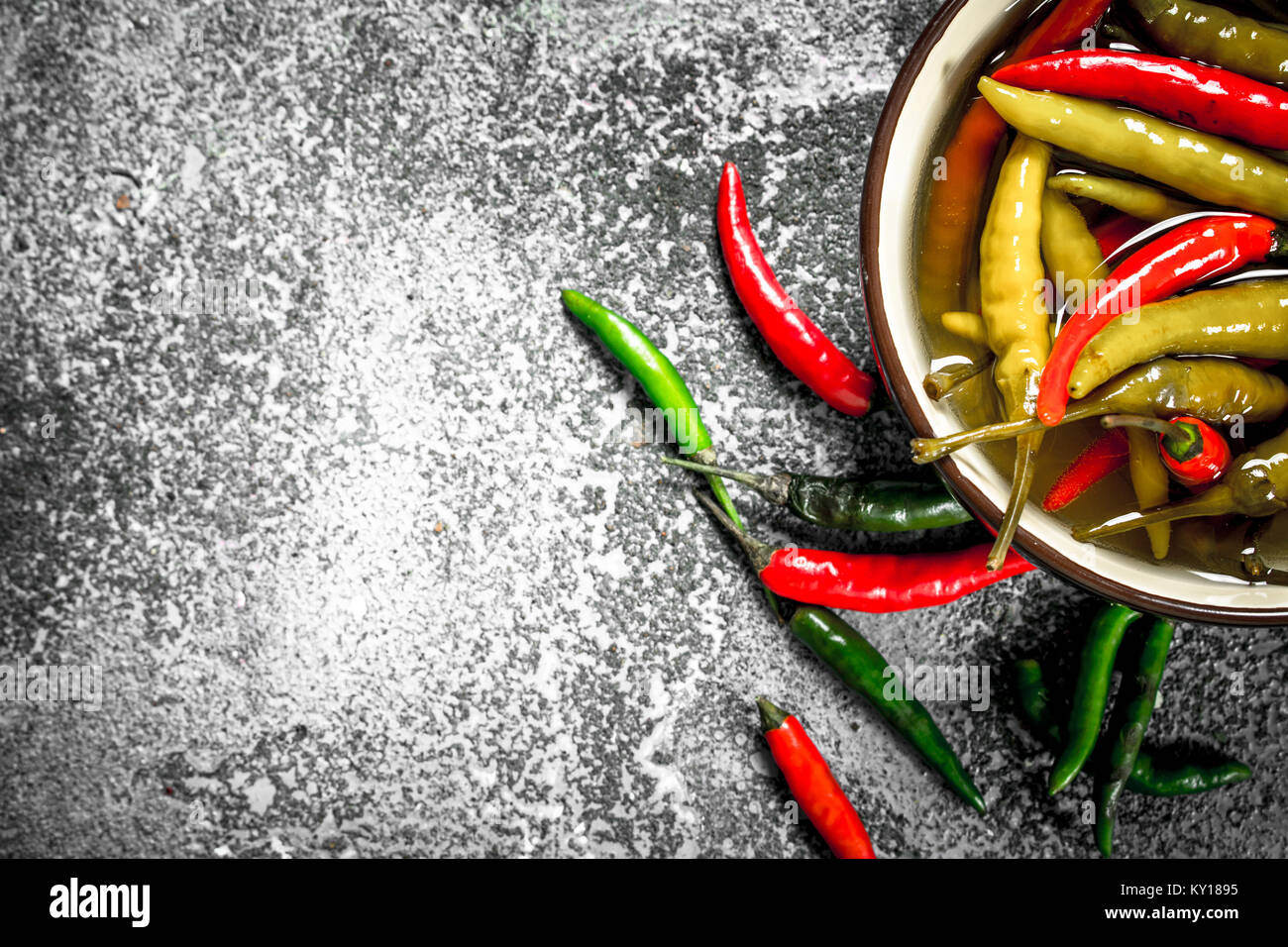 Pickled chili peppers in a bowl. On a rustic background Stock Photo - Alamy
