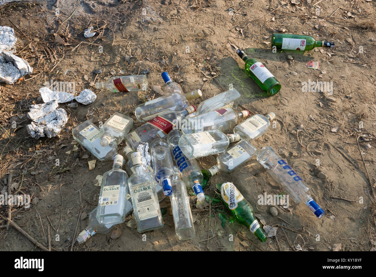 Discarded empty alcohol spirits bottles and other trash left in park