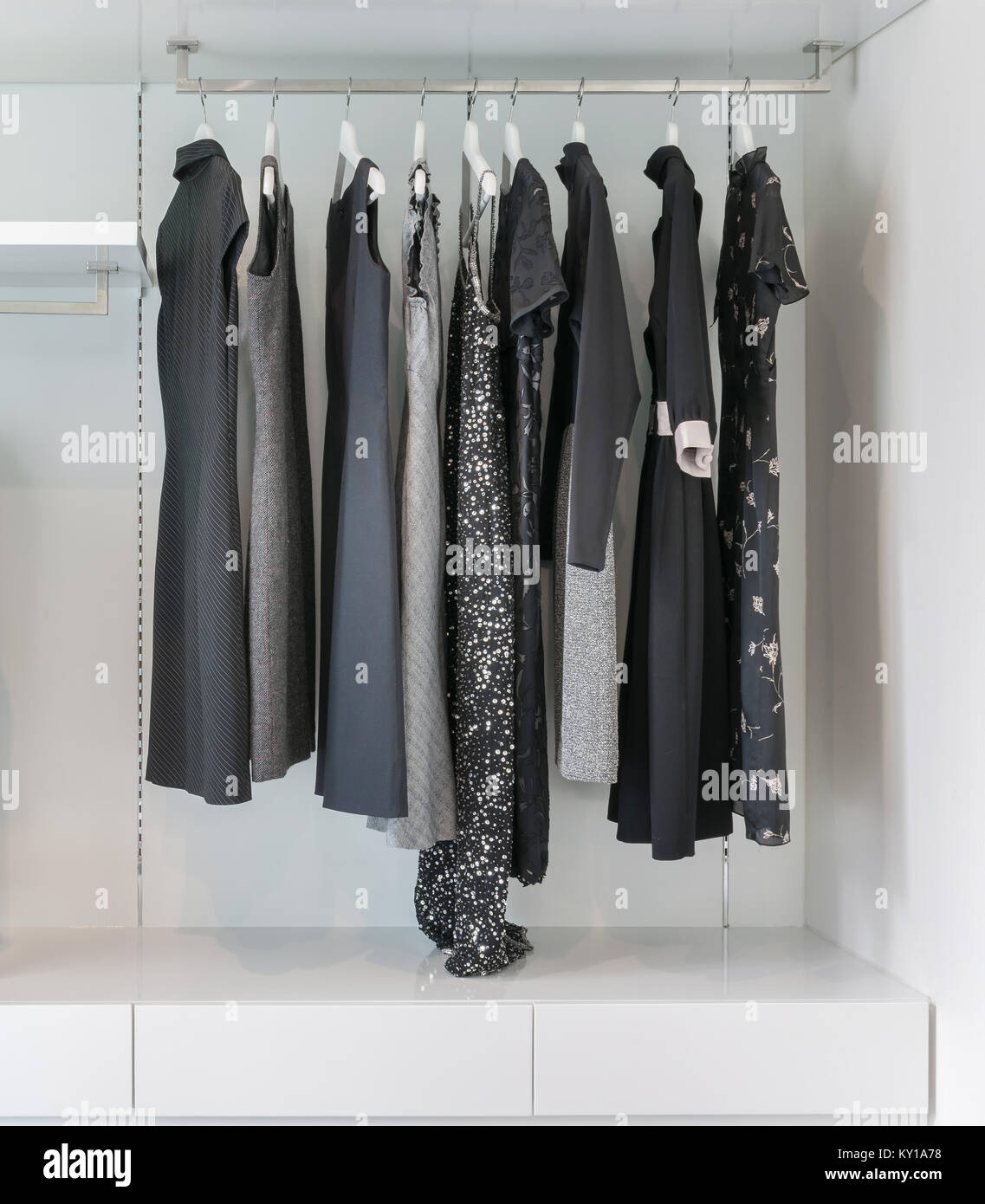 Modern Closet With Row Of Black Dress Hanging In White Wardrobe
