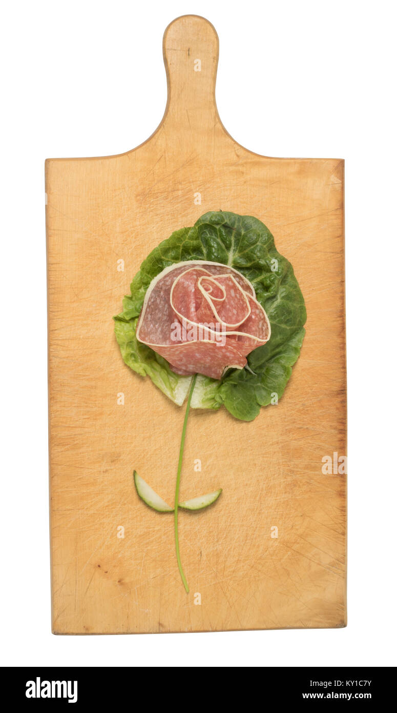 Creative rose made with salad and sausage on cutting board Stock Photo
