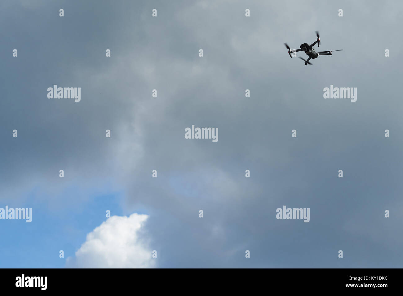 Small drone fly in air on cloudy sky background Stock Photo