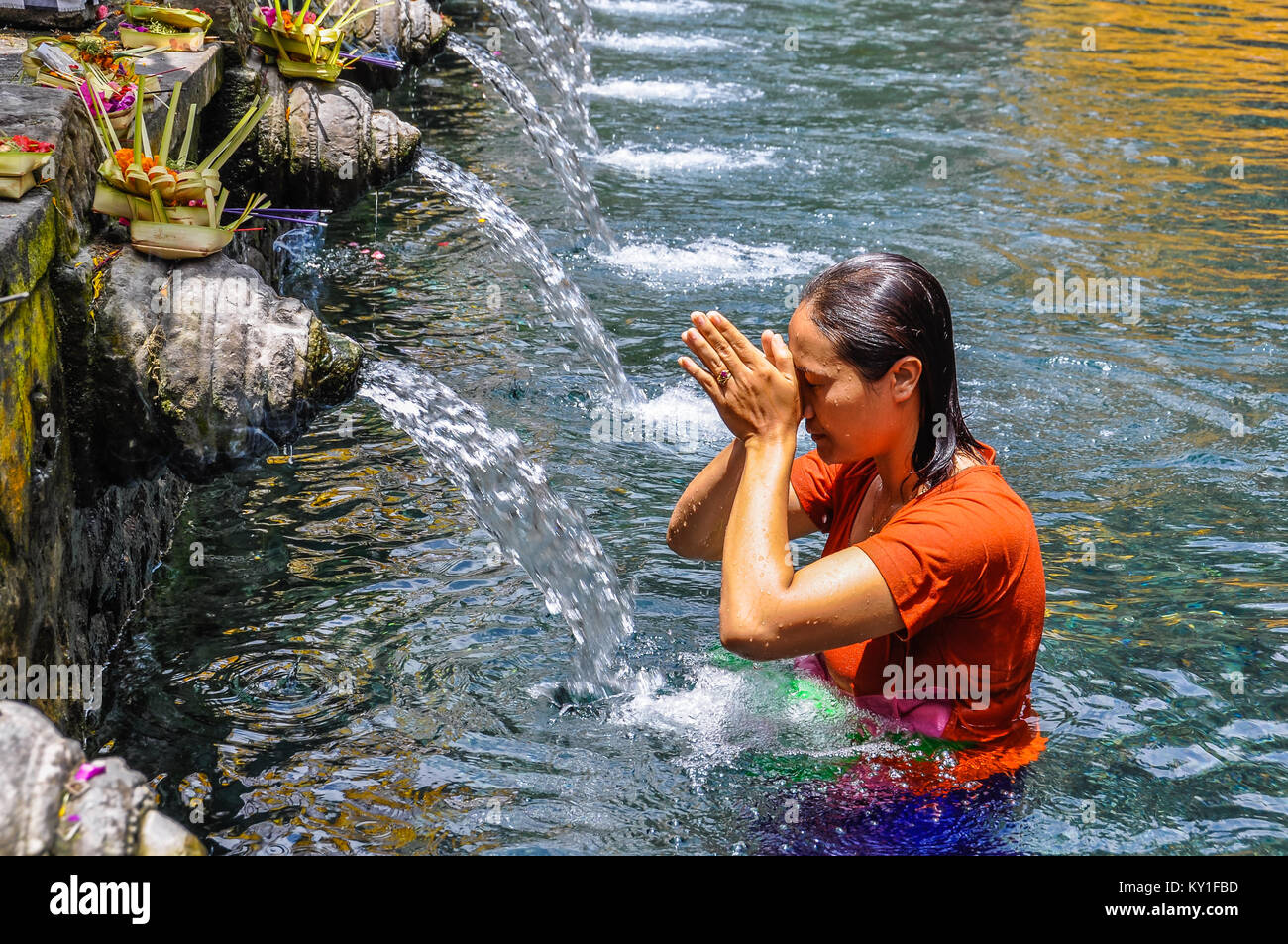 Balinese woman taking purifying bath in the Tirta Empul Temple in Bali, Indonesia Stock Photo