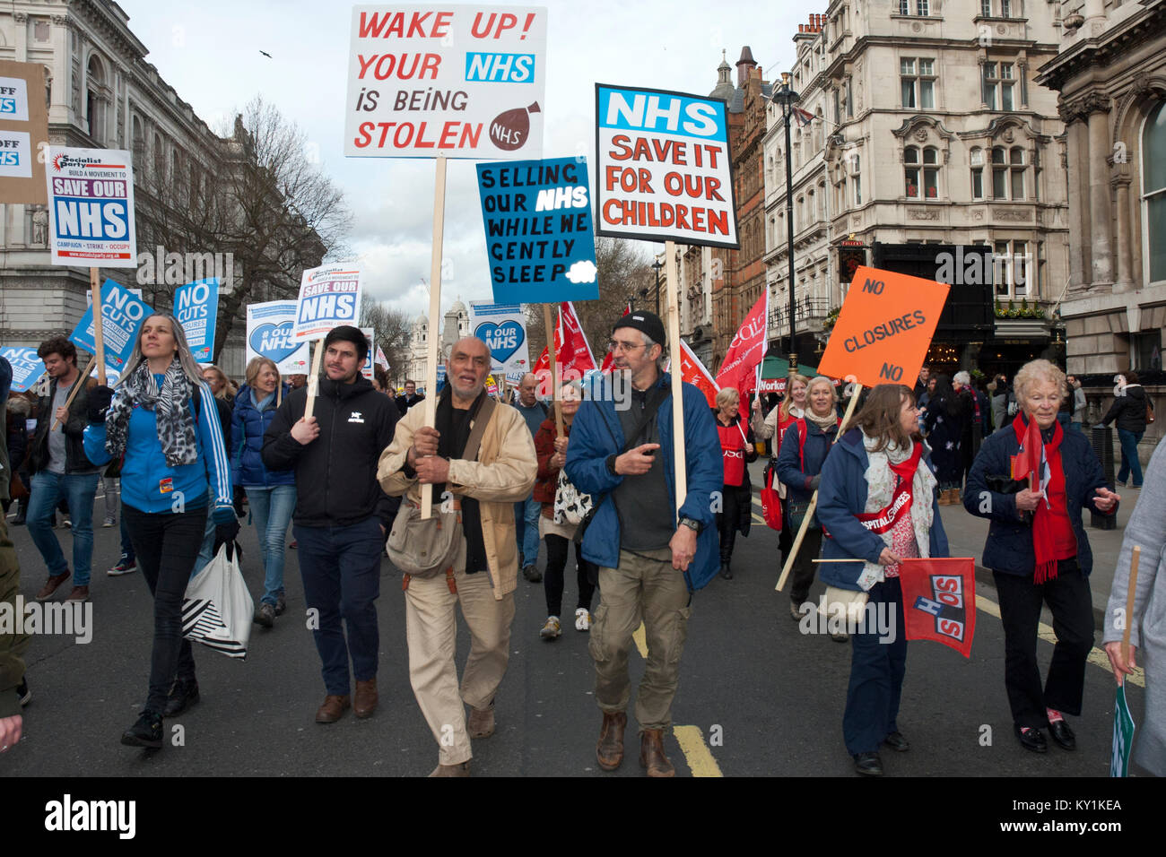 lively demonstration and protest in support of NHS, placards 'Wake up your NHS being stolen' 'NHS save for our children'. Colourful action. London UK Stock Photo