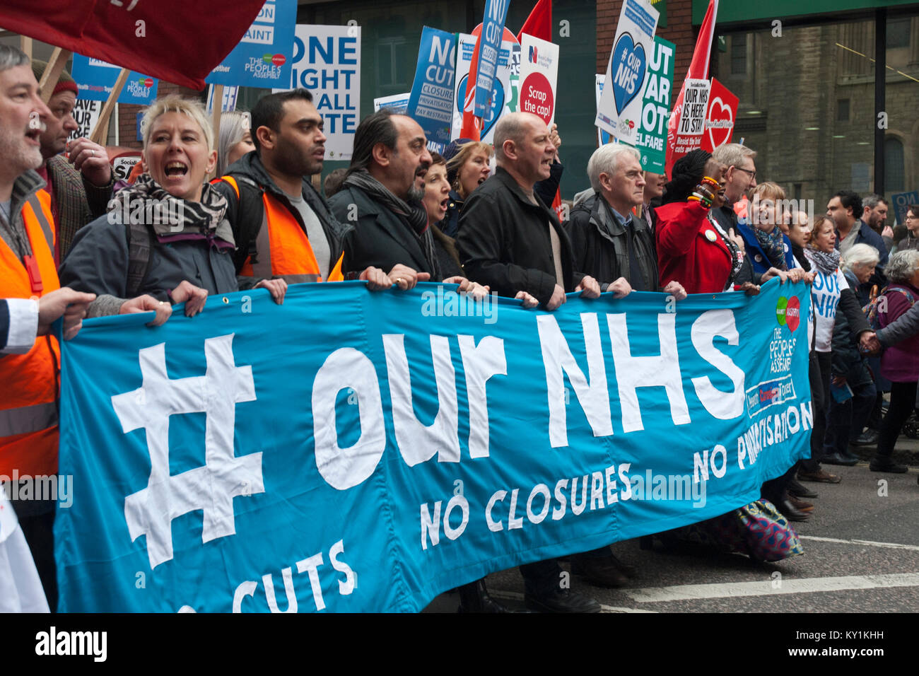 Lead banner of demonstration 'Our NHS', colourful with many people and placards with John McDonald, shadow Chancelor, leading the protest. Stock Photo