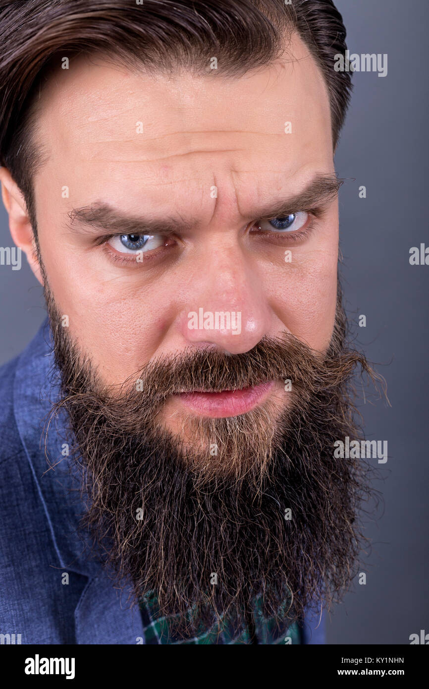 Studio shot of a young  man with beard and mustache.Gray background Stock Photo