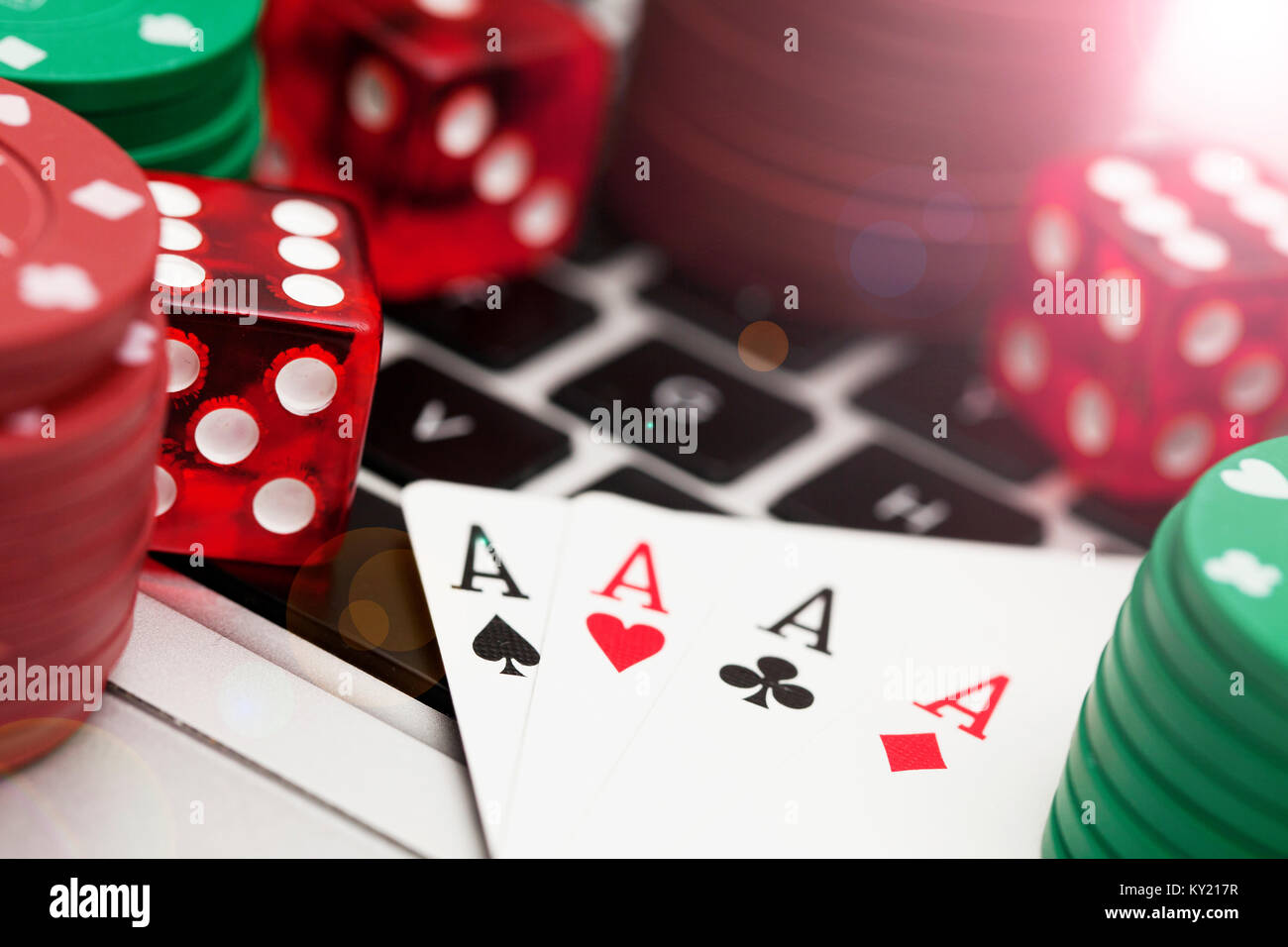 Online gambling. Playing cards, dice and betting chips on a computer keyboard Stock Photo