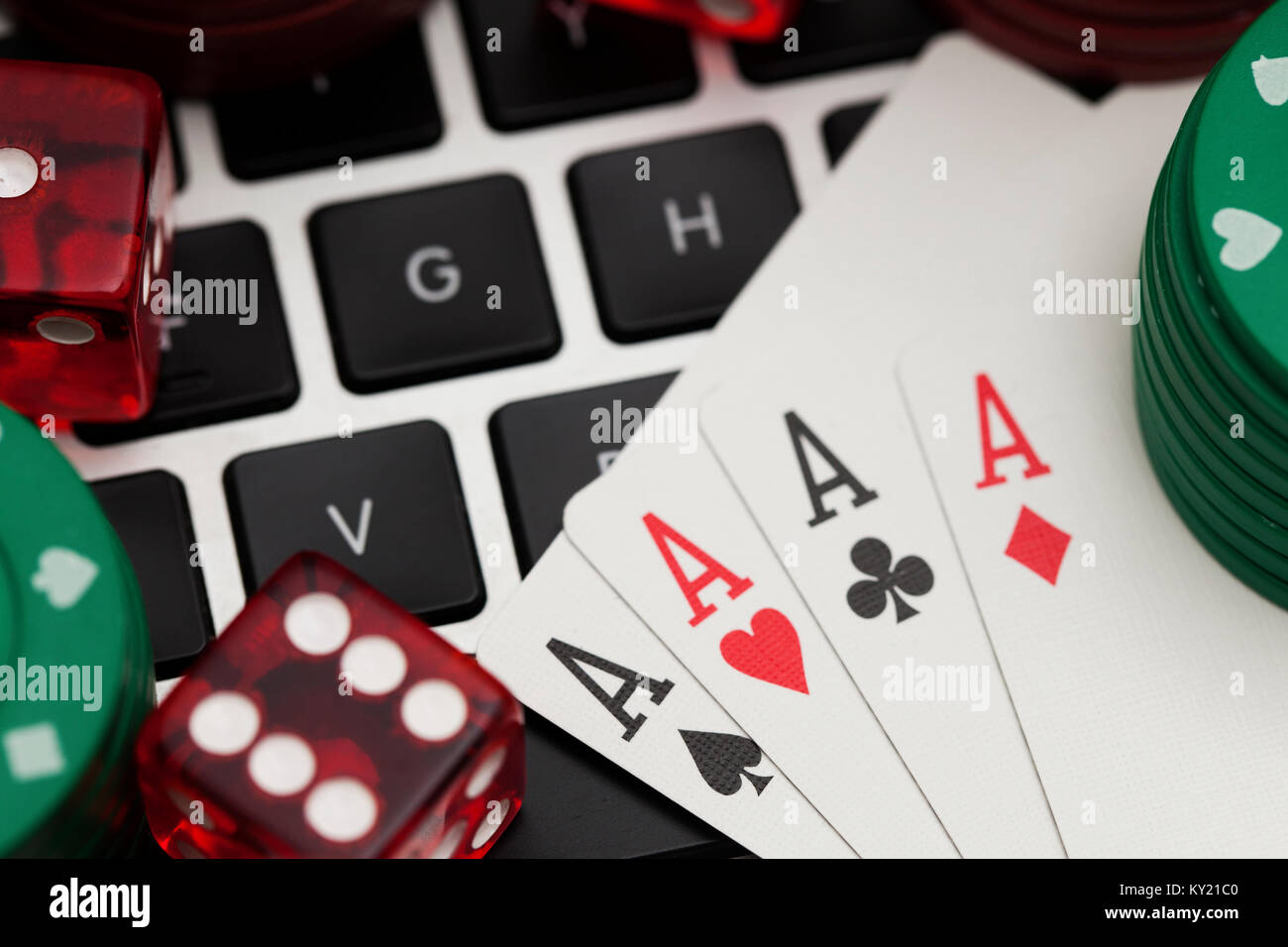 Online gambling. Playing cards, dice and betting chips on a computer keyboard Stock Photo