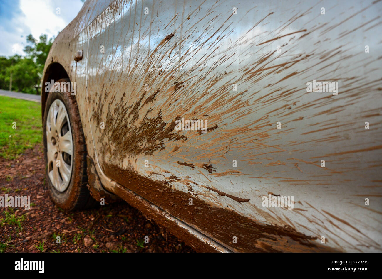 Closeup of muddy car wheel and mud splattered body near wheel arch