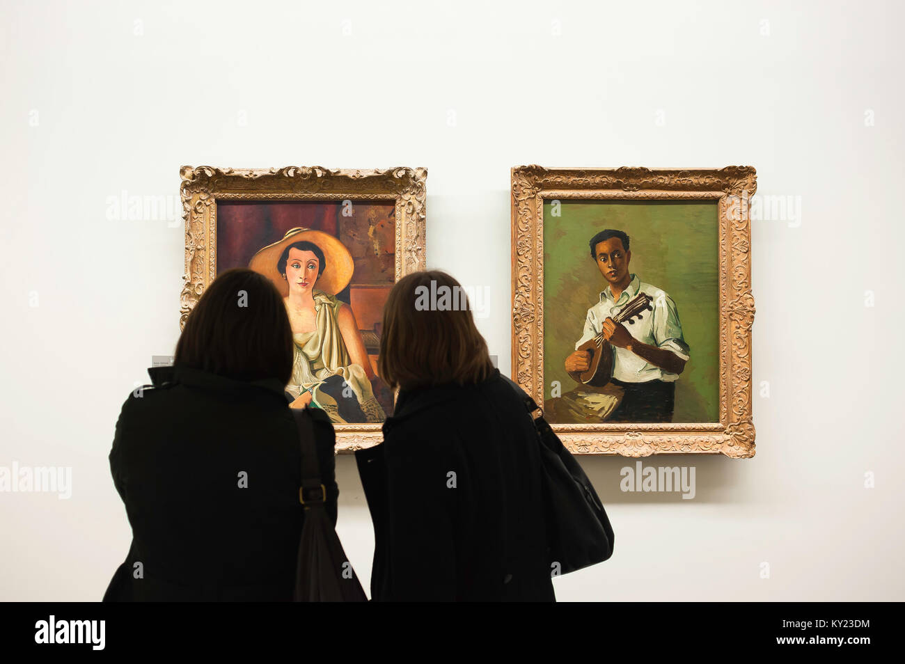 Women looking at a painting, two women study a painting by Andre Derain titled 'Madame Paul Guillaume' in the Musee de L'Orangerie in Paris  France Stock Photo