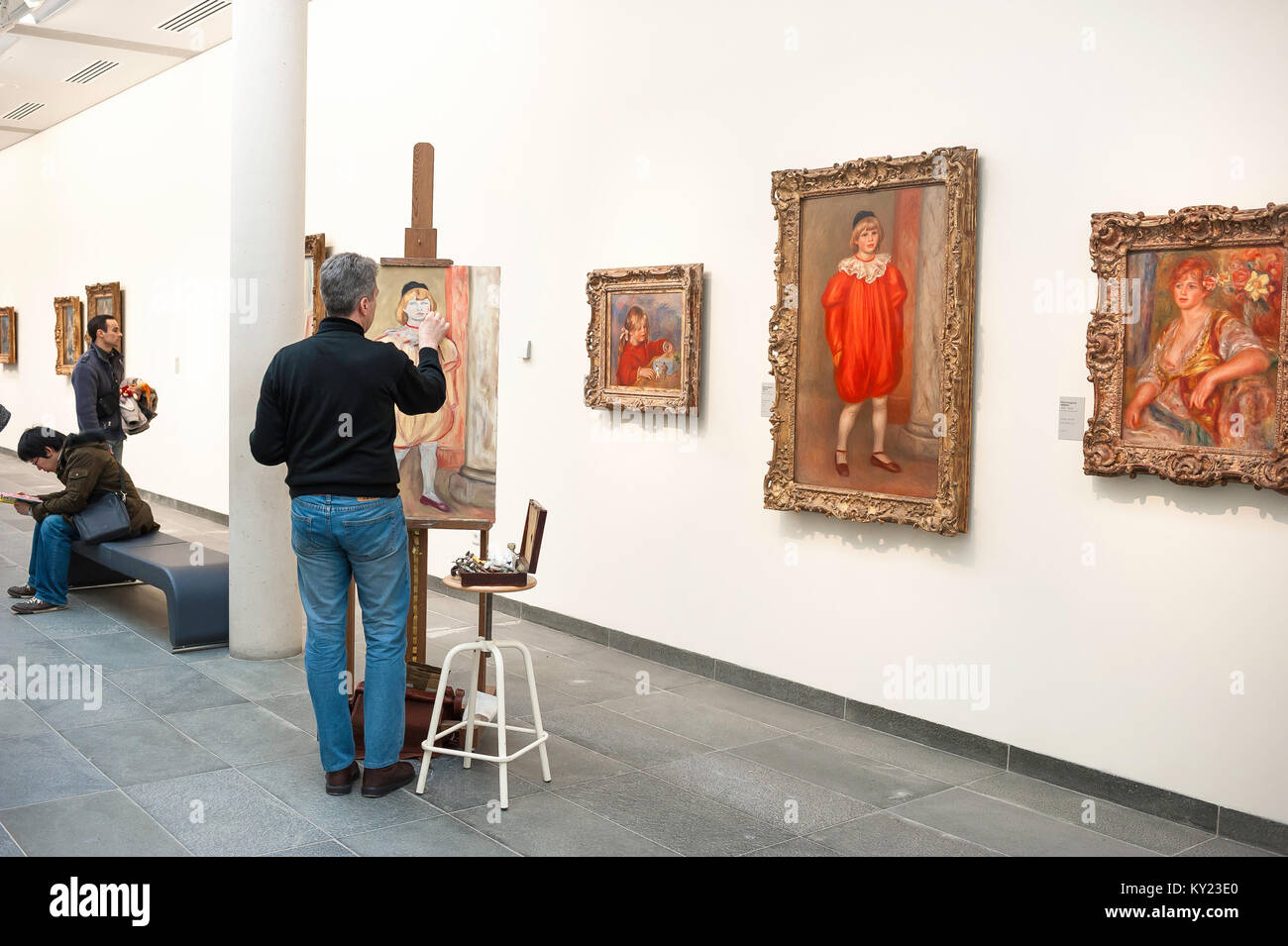 Man painting picture, view of a man copying a painting by Auguste Renoir titled Claude Renoir en Clown in the Musee de L'Orangerie in Paris , France. Stock Photo