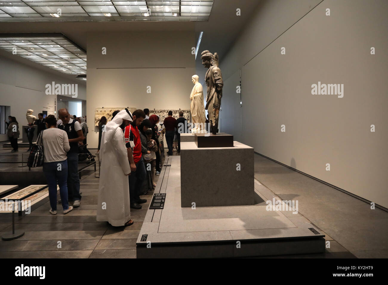 Abu Dhabi, UAE. 12th January, 2018. Visitors examine the displays in the Louvre Abu Dhabi in the UAE capital on 12 January 2018. The museum opened on Saadiyat Island in November 2017, with a collection based on items held by the Louvre in Paris, France. The building was designed by Jean Nouvel. Credit: Dominic Dudley/Alamy Live News Stock Photo