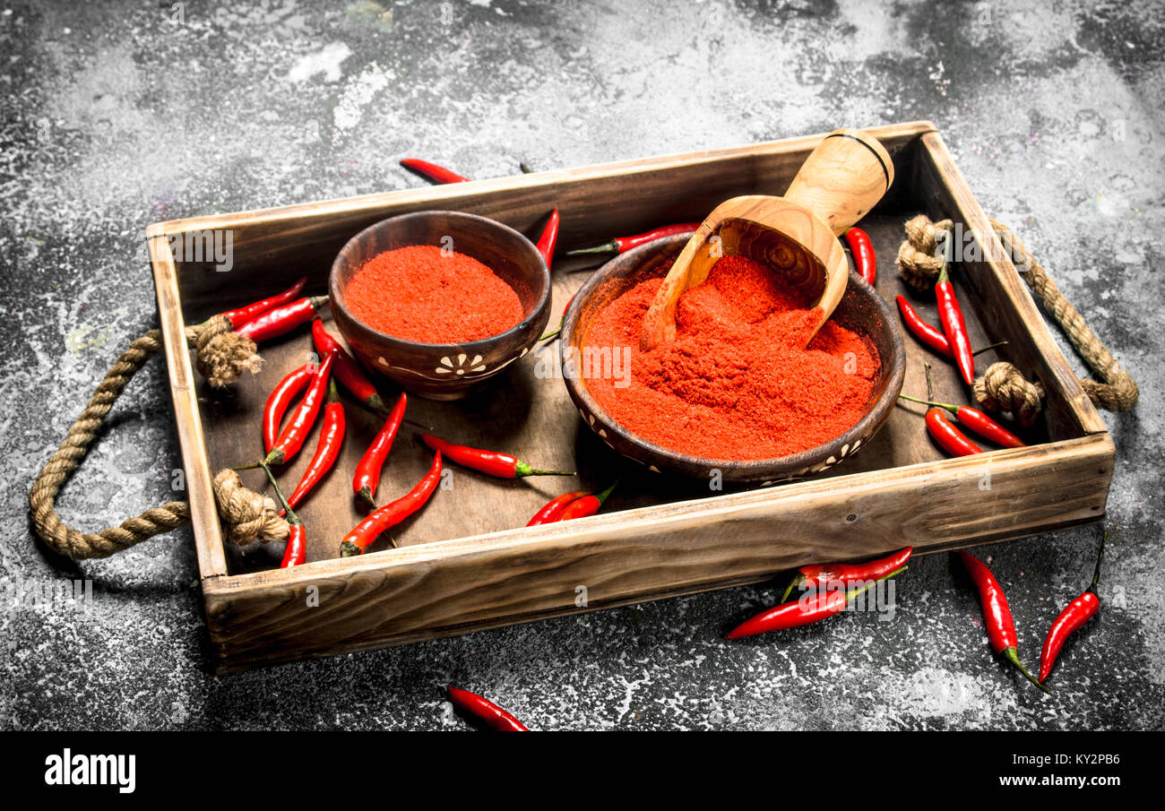 Fresh ground hot pepper in a bowl on a tray. On a rustic background