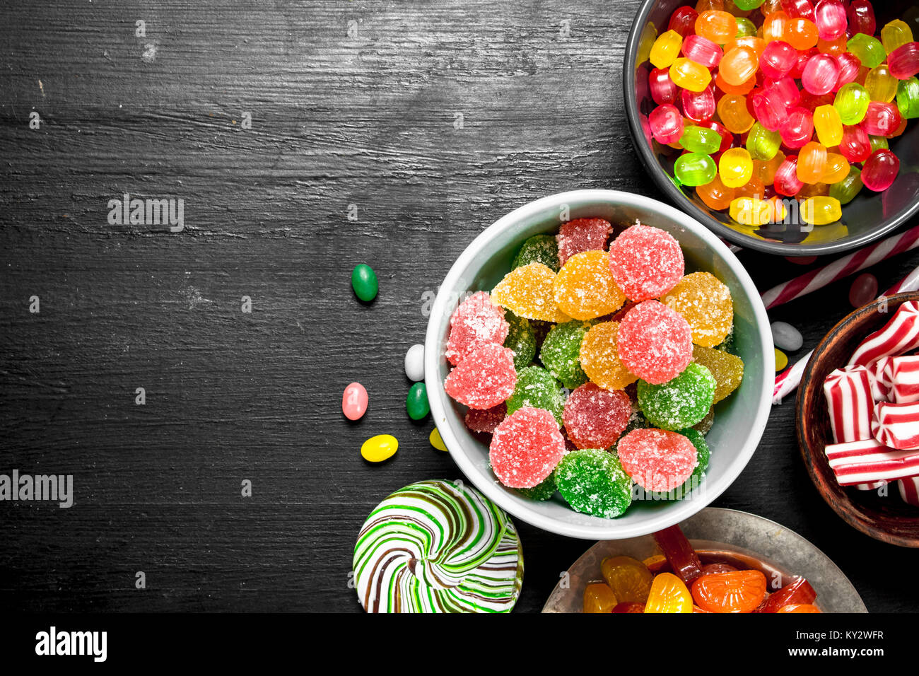 Different sweet candy, jelly and candied in a bowl. On the black
