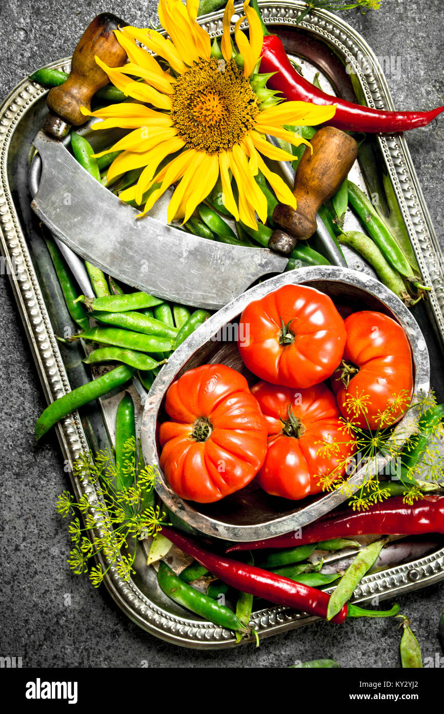 Organic food. Green peas, tomatoes and hot chili pepper on a steel tray ...