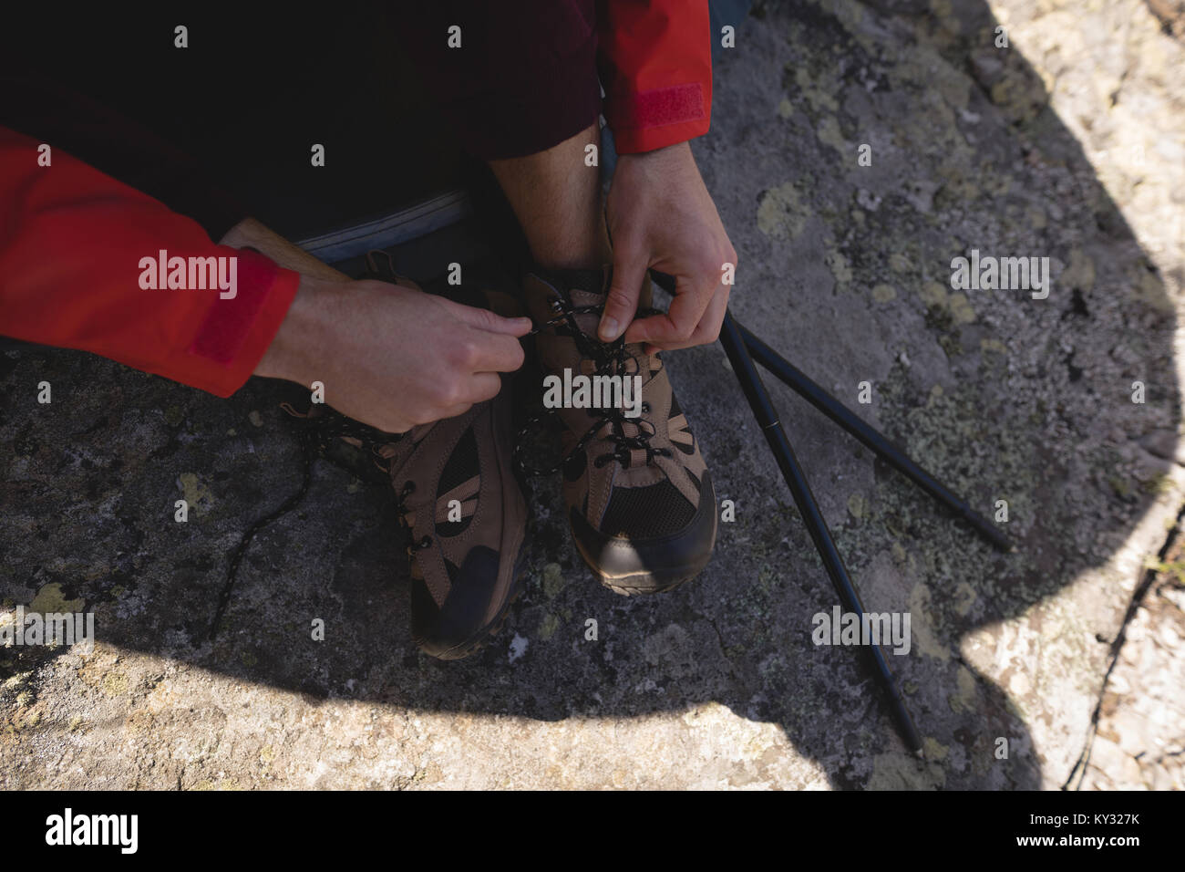 Hiker tying shoes lace on a sunny day Stock Photo