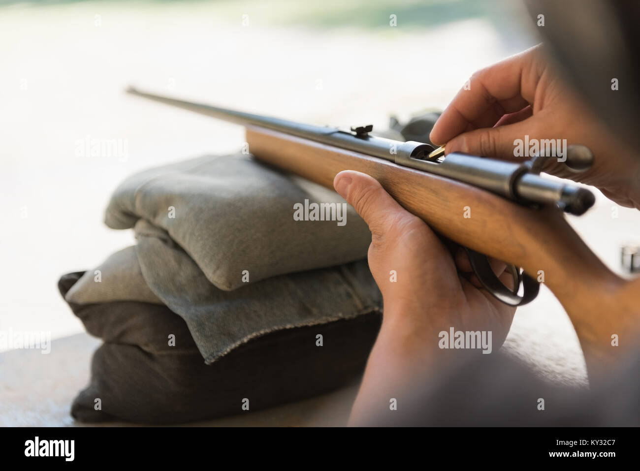 Man loading bullet into shotgun Stock Photo