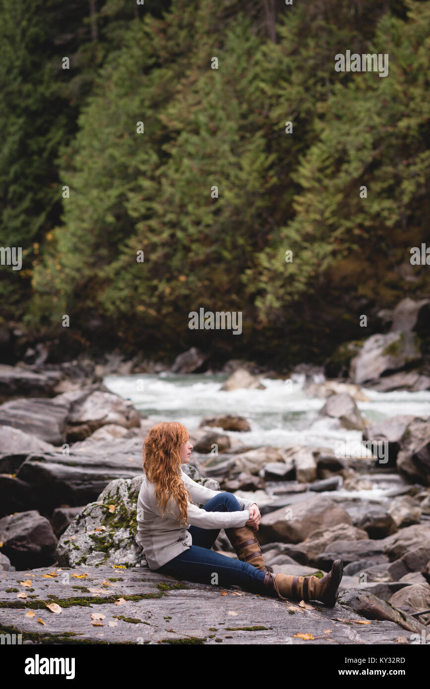 Woman sitting on the river coast Stock Photo