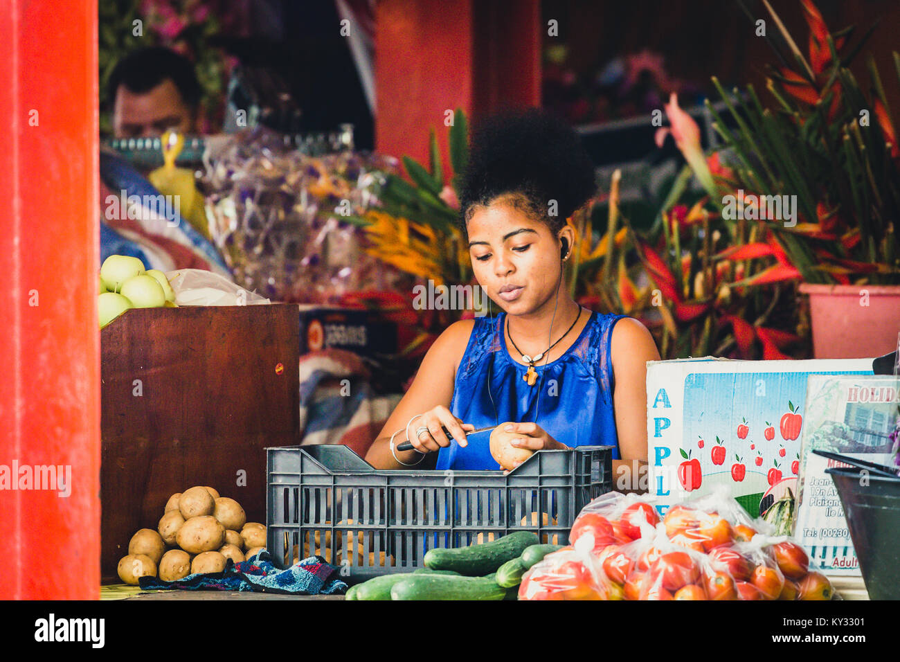 Young African woman peeling potatoes on market Stock Photo