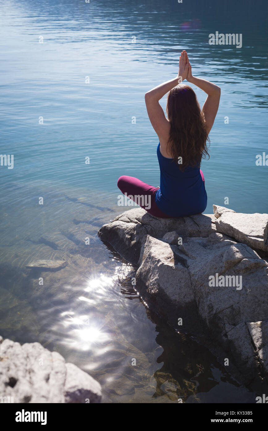 Wellness woman praying on rock hi-res stock photography and images - Alamy