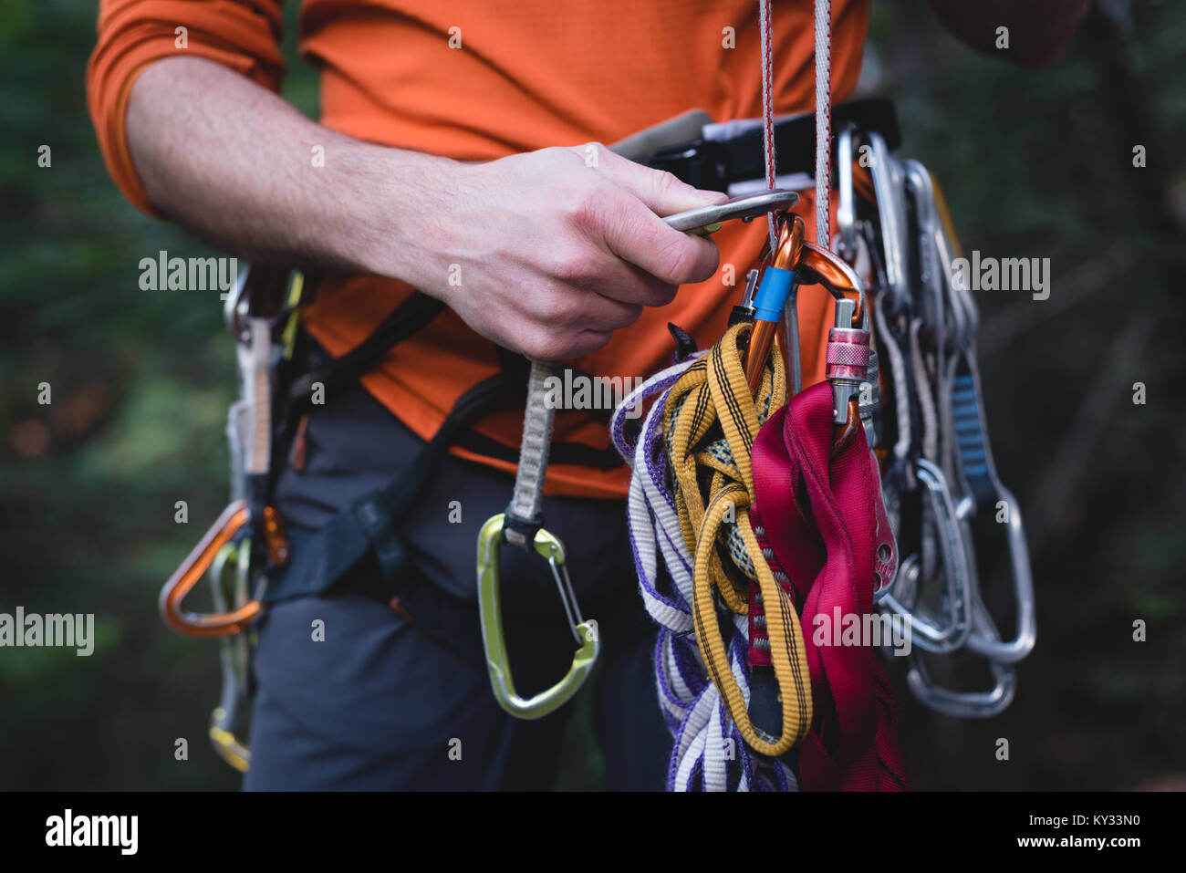 Hiker adjusting the carabiner on rope Stock Photo - Alamy