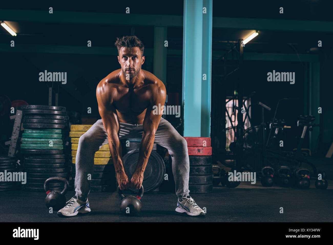Muscular man exercising with kettlebell Stock Photo
