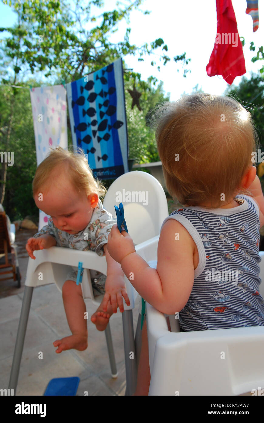 twin boys play with clothes pegs 