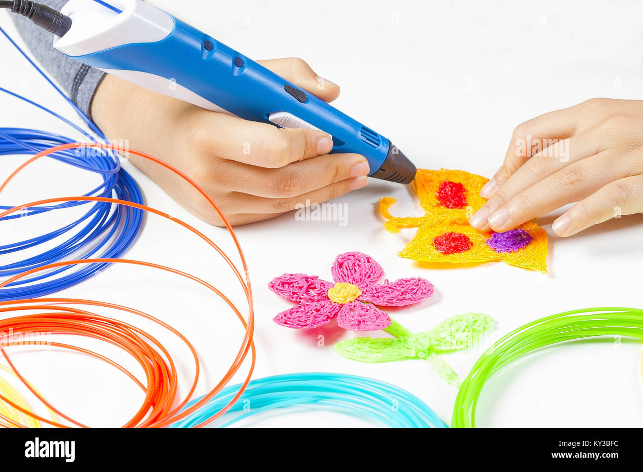 Kid hand holding 3d printing pen and making new item Stock Photo - Alamy