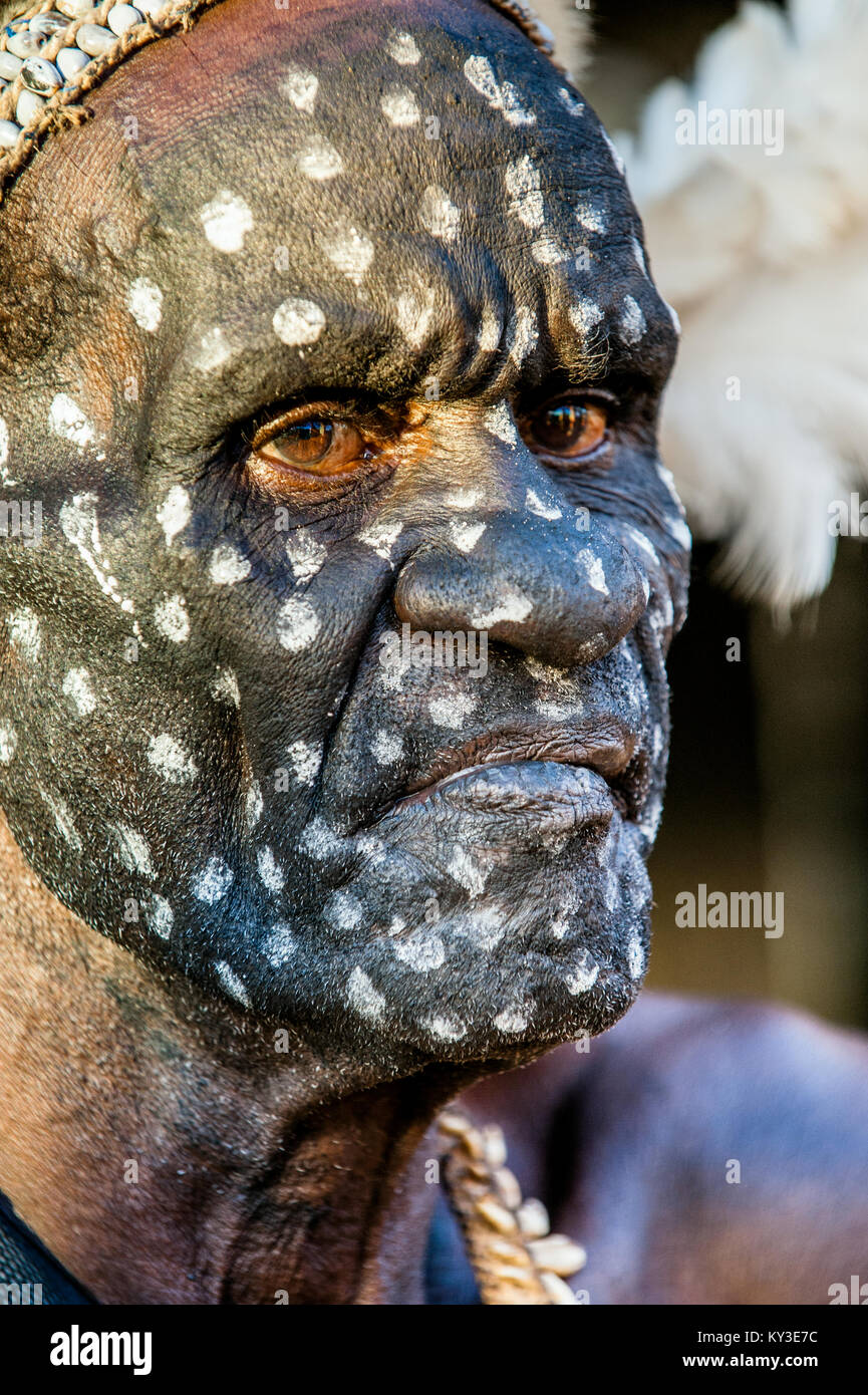 Headhunter of Asmat tribe with a traditional painting on a face, Stock Photo