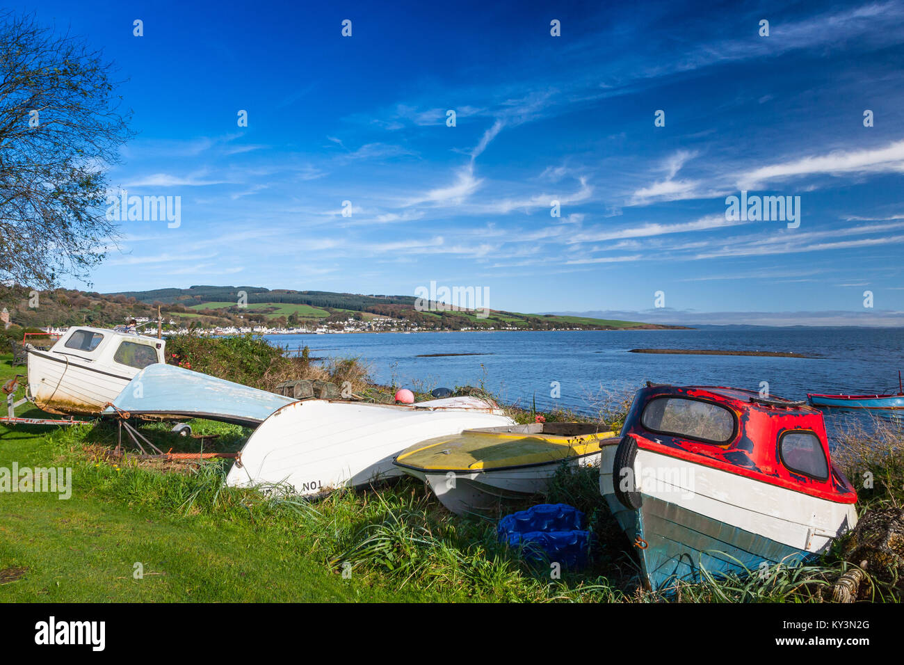 Small fishing boats sitting on a beach at Lamlash Bay, Isle of Arran, Scotland Stock Photo