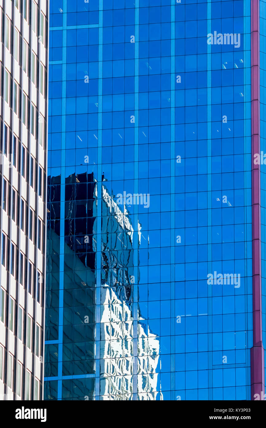 Modern architecture concept, skyscraper reflections in high rise building. Abstract highrise office building reflections, blue and white glass facade. Stock Photo