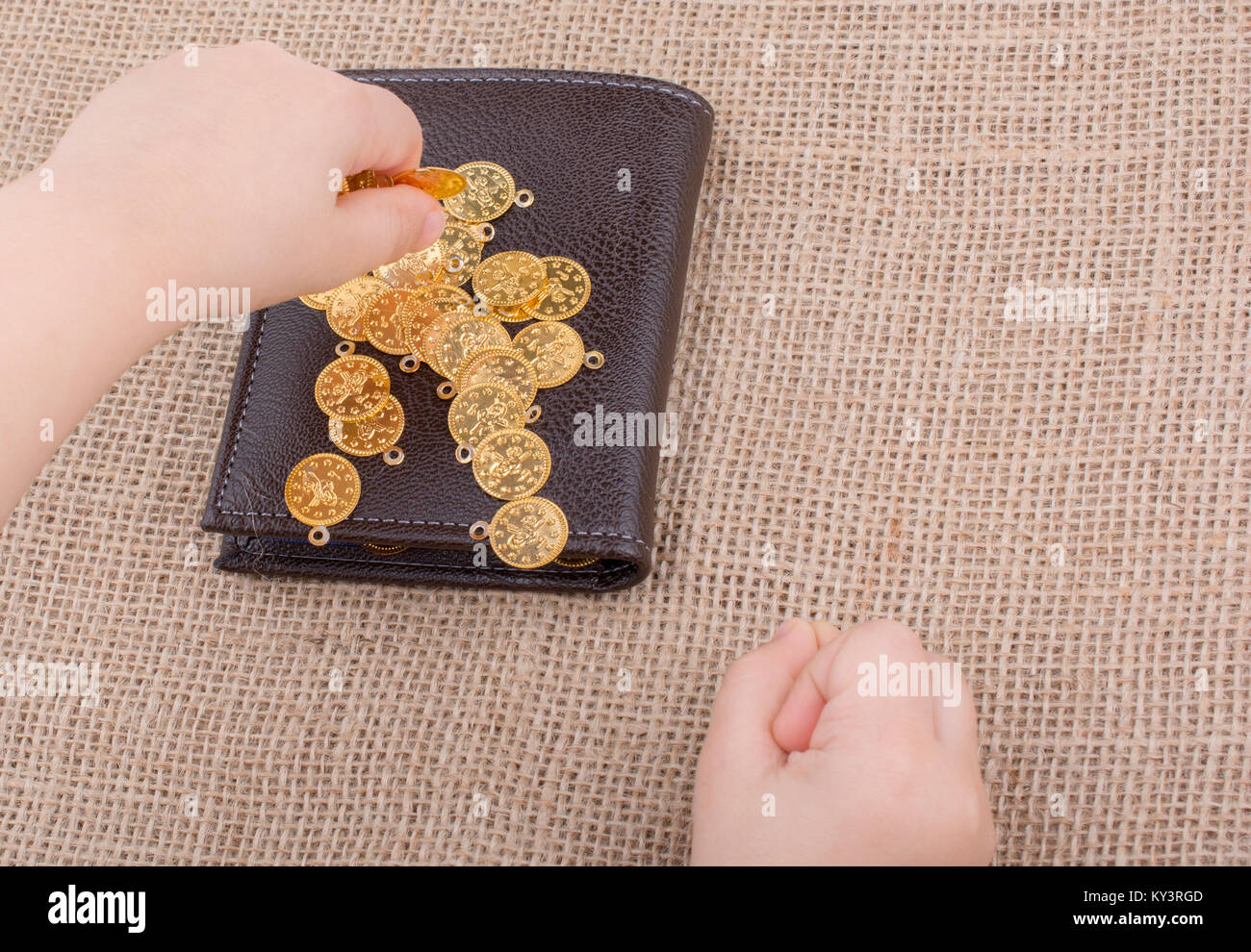 Wallet and plenty of fake gold coins in hnad Stock Photo - Alamy