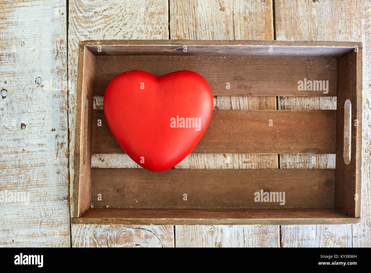 Red heart in a wooden box on the table.  Stock Photo