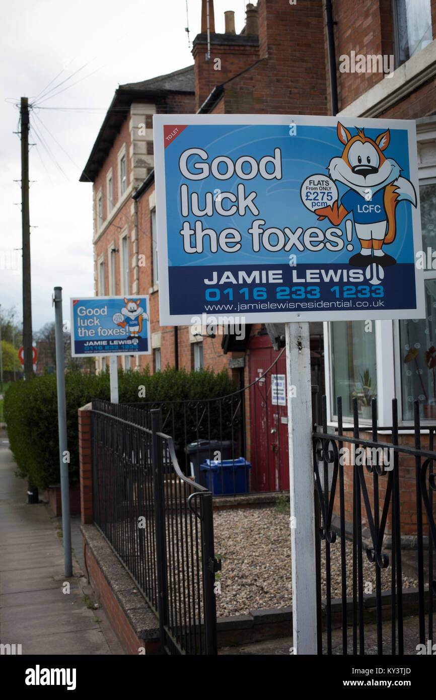 Estate agent advertising signs showing support for the local football club in the English city of Leicester. Leicester City FC were on the brink of being surprise winners of the English Premier League in the 2015-16 season. On that day, they defeated visitors Swansea City by fours goals to nil to open up and eight point lead at the top of the table. Stock Photo