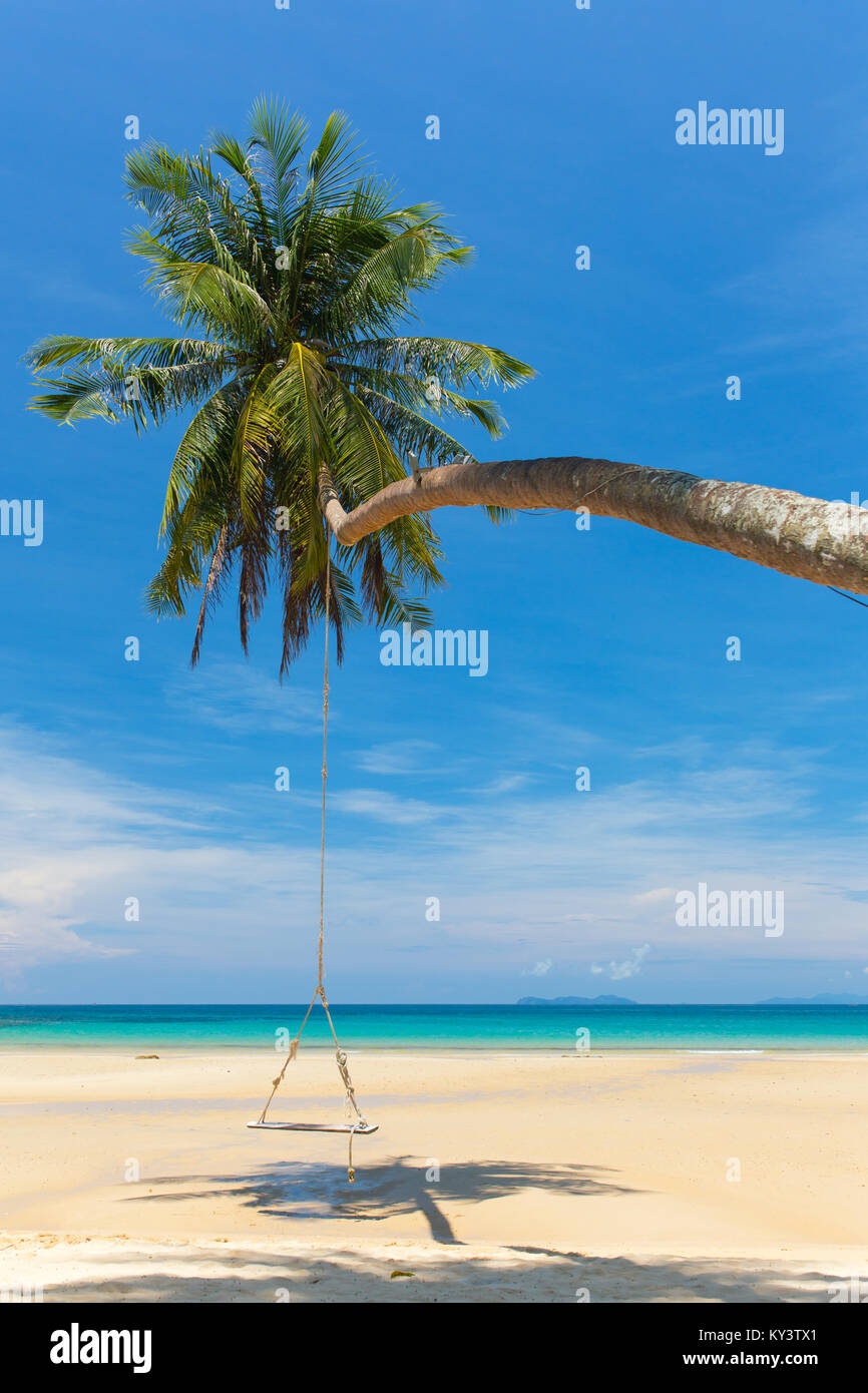 Wooden swing hanging on the beach on tropical island. Stock Photo