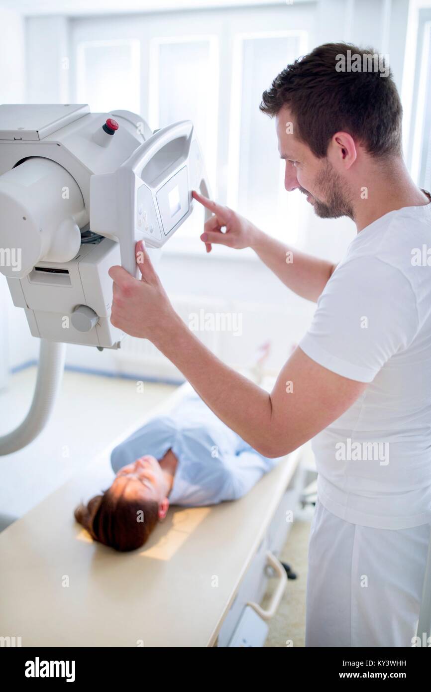 Doctor using xray machine with female patient lying down Stock Photo