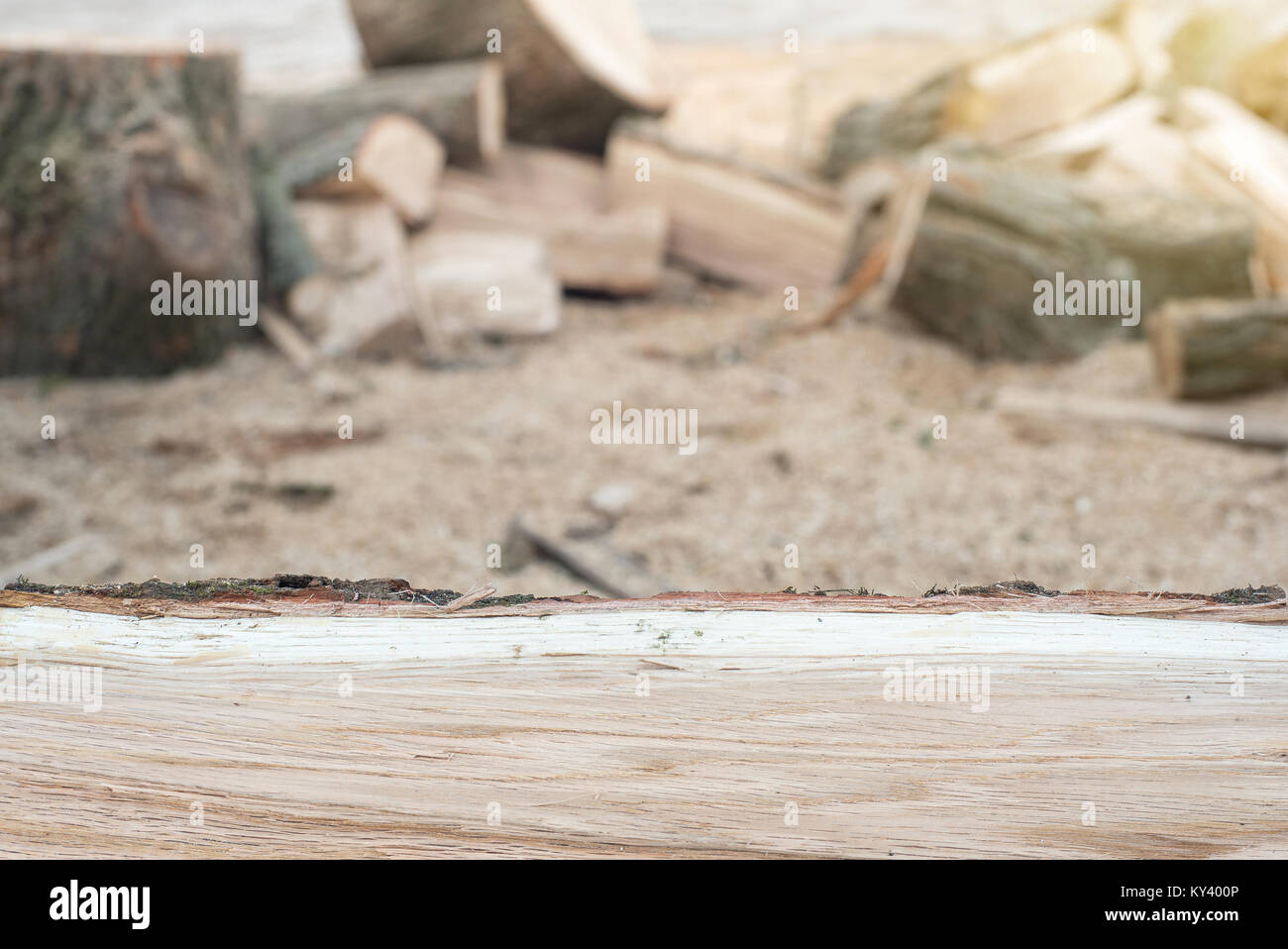 Oak firewood in front of blurry background with copy space, sun flare effect. Preparation for the heating season Stock Photo