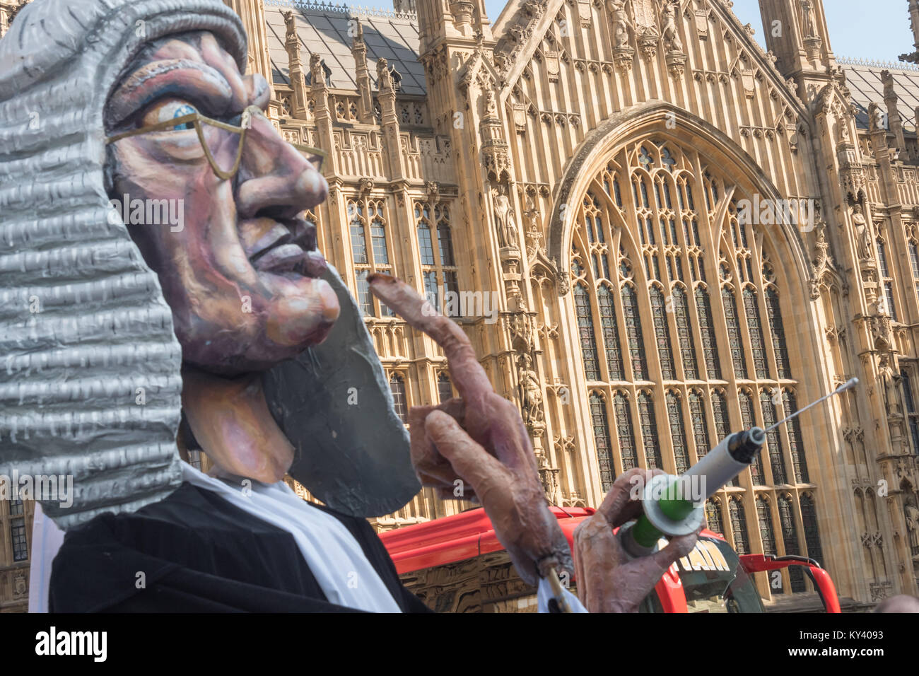 Protesters in Old Palace Yard calling for a NO vote on the Assisted Suicide Bill being debated in Parliament had brought a giant puppet judge with a syringe and the message 'Beware the Slippery Slope'. Stock Photo