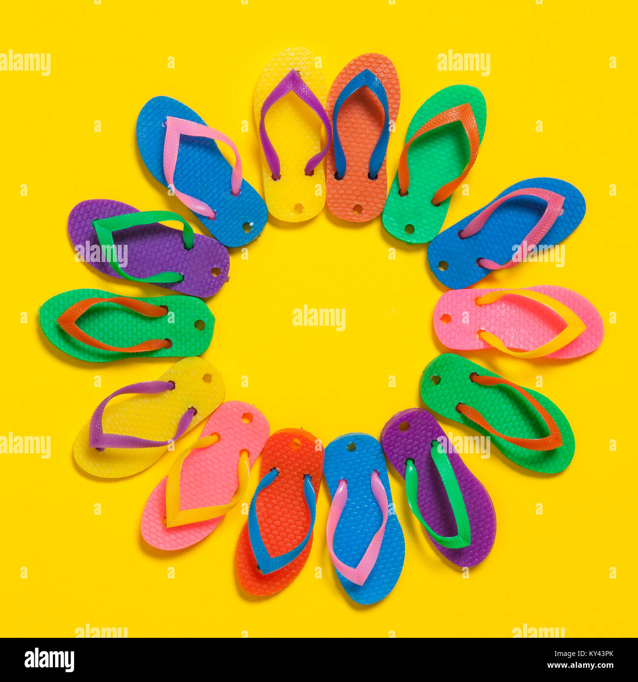 collection of colourful summer flip flop sandals on a bright yellow ...