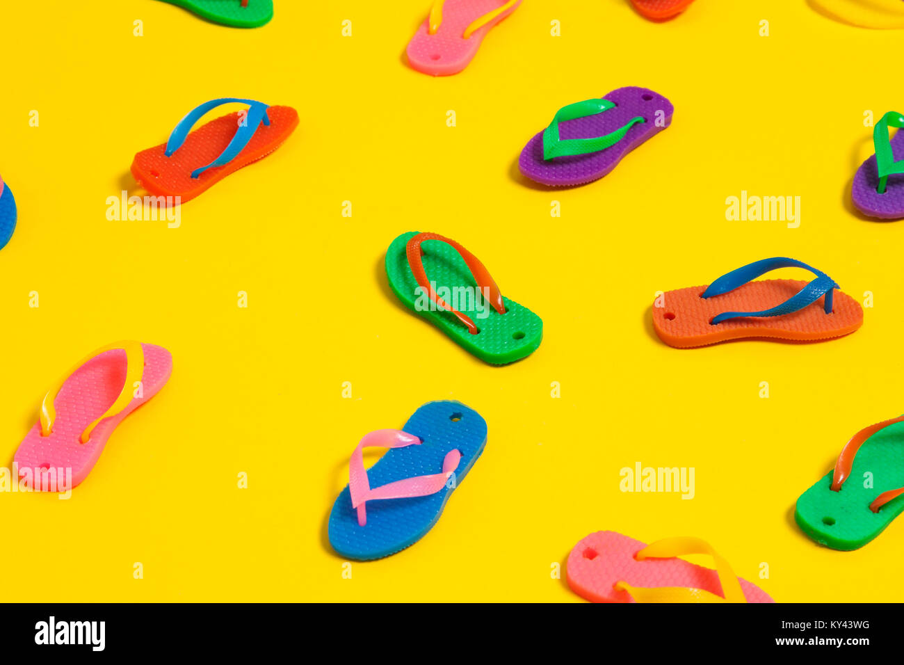 collection of colourful summer flip flop sandals on a bright yellow ...