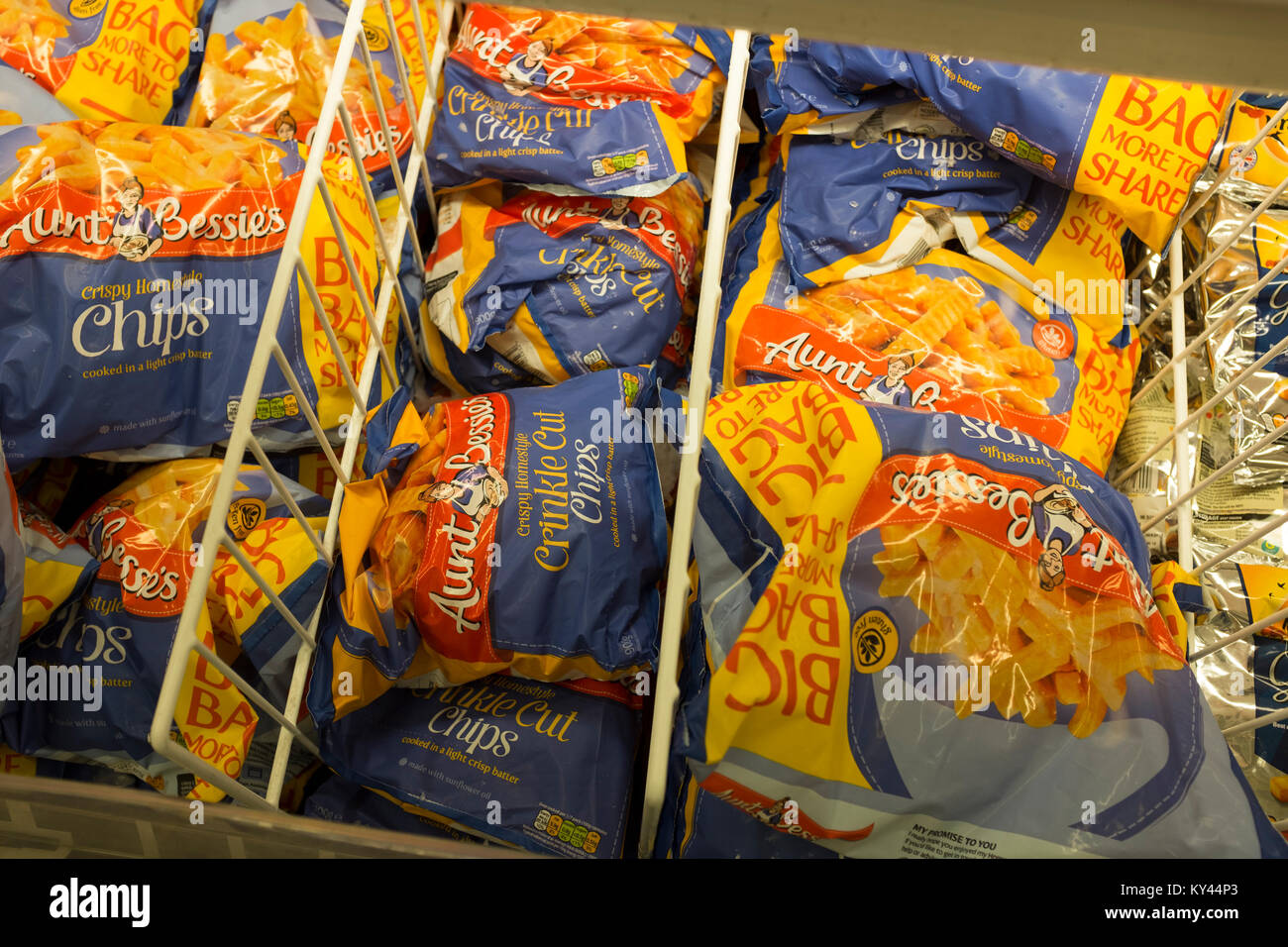 Frozen oven chips plastic packages in freezer at supermarket, UK Stock Photo
