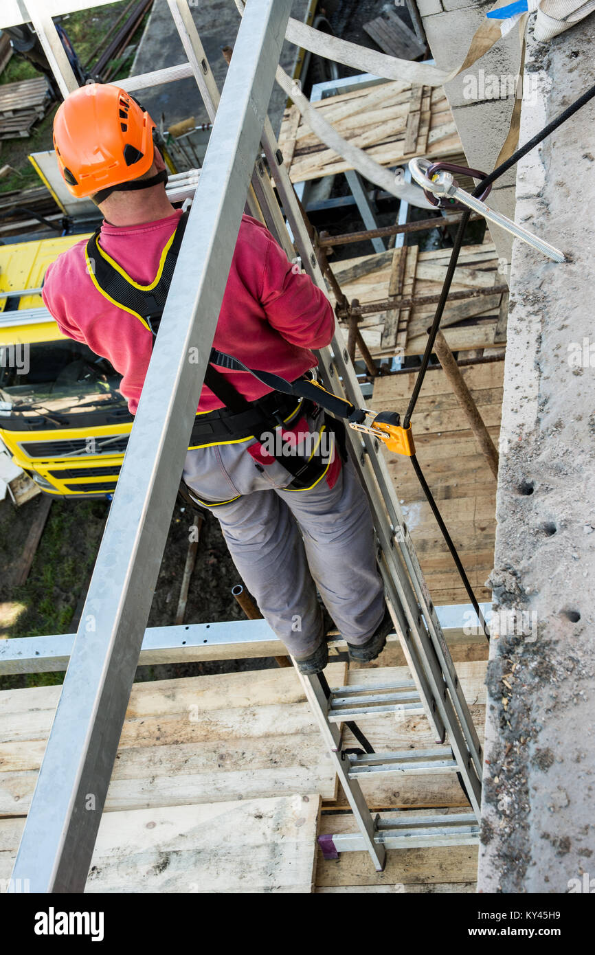 Height works on building and safety. Belaying of the worker during work on a scaffolding. Stock Photo