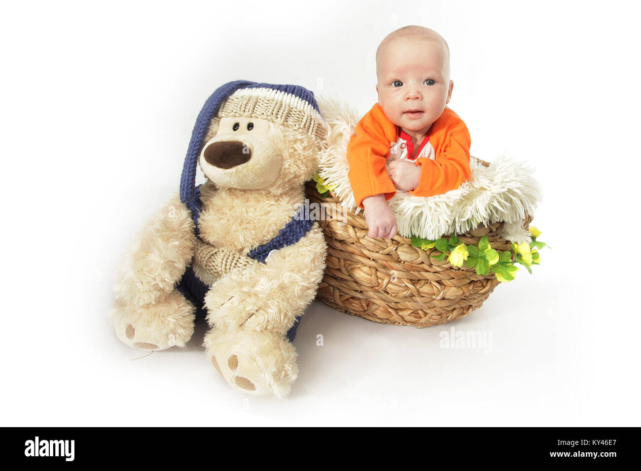 baby boy 2 months old, playing in wicker basket with teddy Stock Photo