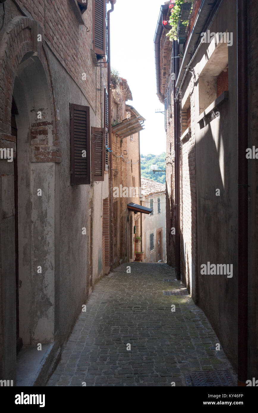 A quiet shady alleyway in the fortified town of Mombaroccio in Northern ...