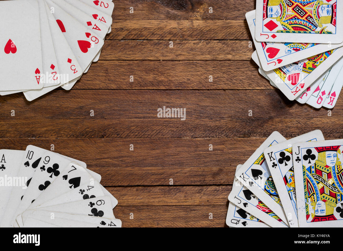 Playing cards on top of a wooden surface, center for copy space Stock Photo